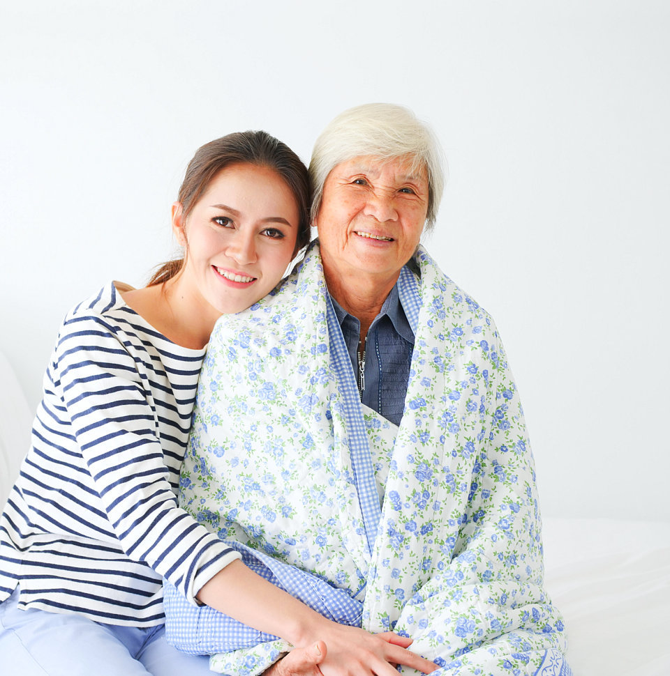 caregiver embraces senior woman